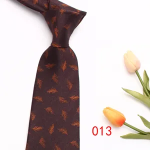 Close-up detail of dark brown patterned mens tie with feather print, premium fabric texture.