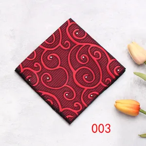 Primo piano dettagliato della pochette rossa e nera con motivi geometrici e fiori decorativi.