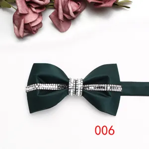 Primo piano di un papillon verde scuro da uomo con dettagli di strass scintillanti e raso.