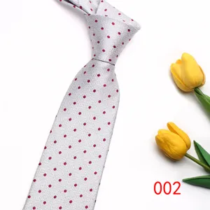 Detailed view of the elegant grey necktie featuring classic red polka dots. Premium fabric.