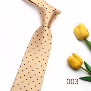 Detailed shot of a classic champagne gold necktie featuring elegant dark blue polka dots.