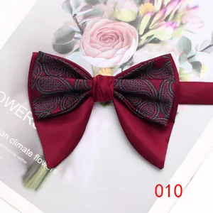 Men's burgundy paisley double layer bow tie, elegant vintage formal neckwear detail shot.