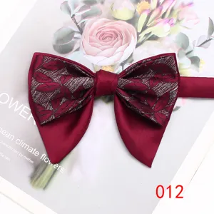 Detailed close-up of a burgundy double layer bow tie with elegant leaf patterned fabric.