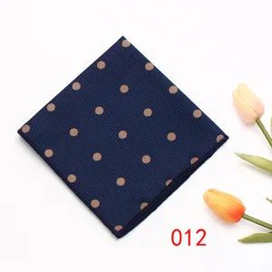 Detailed view of the dark blue pocket square featuring elegant gold polka dot patterns.