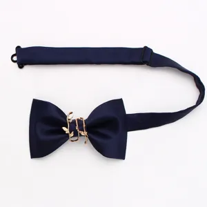 Dettaglio in primo piano del farfallino blu scuro che mostra l'elegante fibbia dorata.