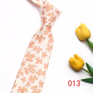 Detail shot of men casual tie featuring elegant orange maple leaf pattern on light fabric.