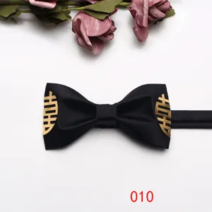 Black groom bow tie with gold Chinese double happiness symbol for wedding suit, detail view.