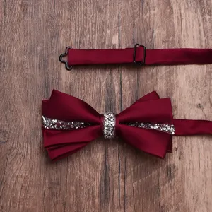Dettaglio farfalla doppia in strass bordeaux, accessorio elegante per eventi formali.