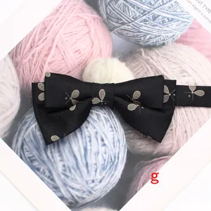 Vue détaillée du nœud papillon noir à double couche avec motif de raquette doré chic.