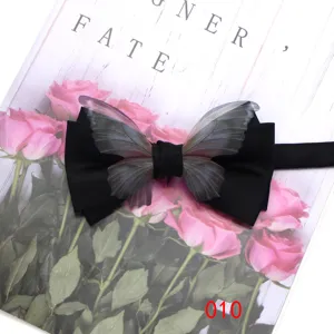 Close-up detail of a black bow tie featuring translucent butterfly wings for elegant suits.