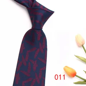 Close-up detail of dark blue men's necktie featuring burgundy feather jacquard pattern.