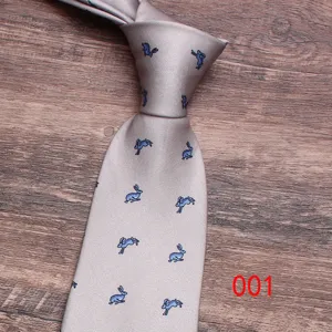 Detail shot of a grey necktie featuring a cute blue jumping rabbit pattern print close-up.