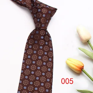 Brown floral mens necktie detail close up, elegant small print pattern formal wear tie.