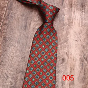 Vue rapprochée détaillée de la cravate rouge avec motif de médaillon géométrique vert et bleu.
