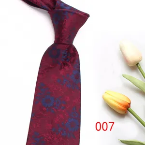 Close up detail of wine red floral patterned men formal necktie fabric texture display.