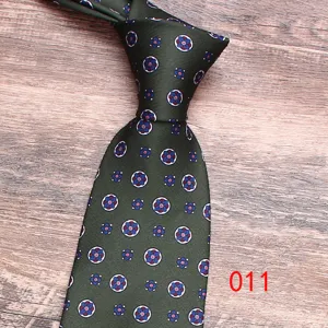 Close-up detail of a dark green silk tie featuring elegant medallion floral print patterns.
