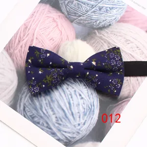 Dettaglio in primo piano del papillon in cotone blu scuro con delicata stampa floreale.