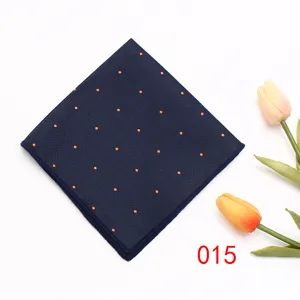 Gedetailleerd overzicht van de donkerblauwe pochet met chique oranje stippen en fijne stof.