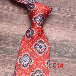 Detailed shot of a classic red paisley pattern men necktie on a textured wood background.