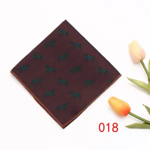Detailopname van een heren pak pochet met een elegant paardenpatroon op een bordeauxrode stof.