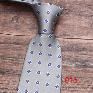 Men's grey floral tie detail shot, elegant business casual necktie with blue flower pattern.