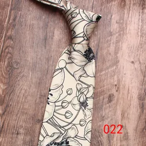 Gros plan cravate homme imprimé floral, tissu beige élégant avec motif de fleurs noires classiques.