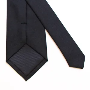 Classic black tie detail view, premium textured fabric, elegant craftsmanship closeup.