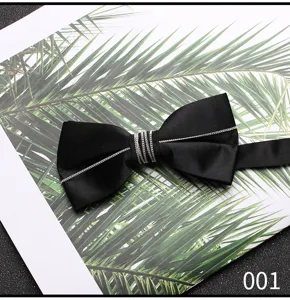 Primo piano di un farfallino nero da uomo con elegante catenella argentata e finitura liscia.