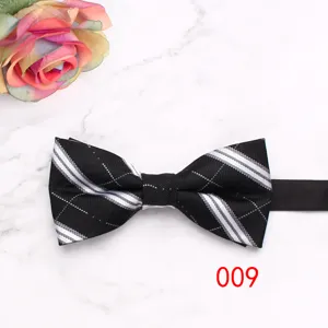 Close-up detail of the black plaid bow tie, featuring classic white stripes and neat stitching.