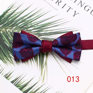 Detailed closeup of a stylish dual-layer bow tie with blue and burgundy leaf print.