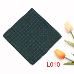 Detalle de pañuelo de bolsillo verde oscuro estampado, accesorio geométrico de traje.