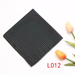 Vista de detalle cercana del elegante pañuelo de bolsillo con patrón de cuadros y lunares rojos.