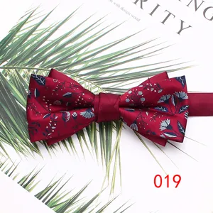Burgundy men's double layer bow tie with elegant leaf print pattern for wedding suit detail.
