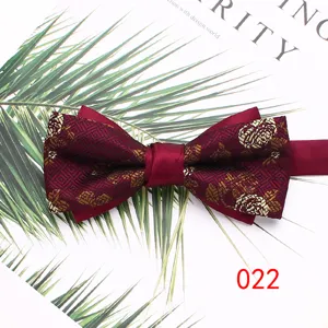 Detailed shot of wine red double layer men bow tie with gold floral jacquard pattern.