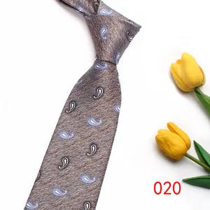 Close-up detail of a classic brown paisley pattern necktie displayed with yellow tulips.