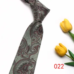 Detailed view of grey and brown paisley pattern fabric necktie, vintage British style prop.