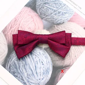 Vue de détail d'un nœud papillon double bordeaux mettant en valeur la texture du motif floral.