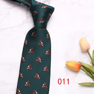 Vue détaillée d'une cravate pour homme vert foncé avec des motifs de chevaux sur marbre.