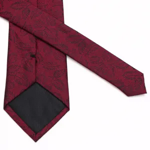 Detailed view of the burgundy men's tie featuring a delicate black leaf jacquard texture.