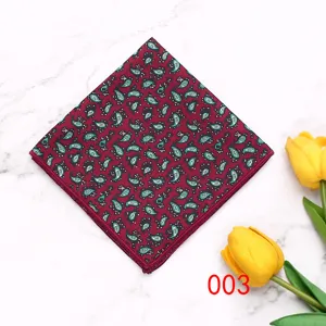 Detailed view of a classic mens paisley pocket square in burgundy with green geometric patterns.