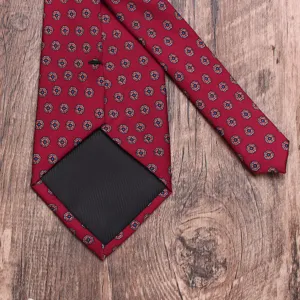 Vue détaillée d'une cravate pour homme rouge à motif floral fin et doublure noire élégante.