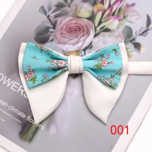 Dettaglio del farfallino doppio con fiori e base in raso bianco per matrimonio uomo.