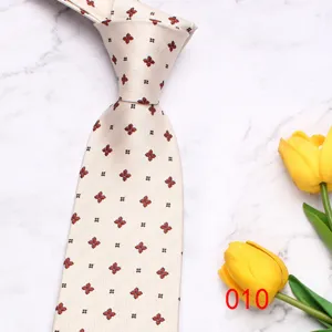 Detailed view of light-colored men's business casual necktie with small floral print.