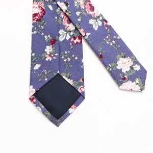 Gedetailleerd uitzicht van een paarse katoenen das met bloemenprint en voering achteraan.