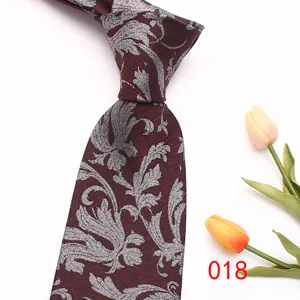 Detailed view of a classy burgundy men's tie featuring intricate silver leaf jacquard patterns.