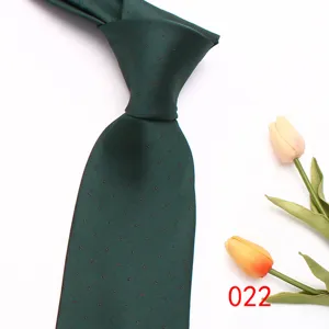 Dark green polka dot necktie close-up, classic business casual men silk tie detail shot.
