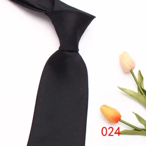 Detail view of black men's business necktie with red polka dots, elegant silk tie.