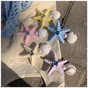 Starfish pearl hair clip detail view, featuring cute shell and blue rhinestone decor.