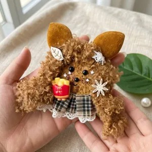 Handmade plush seed pod doll charm detail view showing cute furry design and mini fries toy.