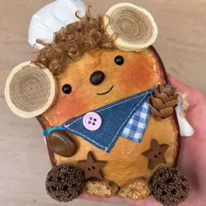 Handmade wooden animal figurine detail shot, rustic craft decor with pinecone and fabric accents.